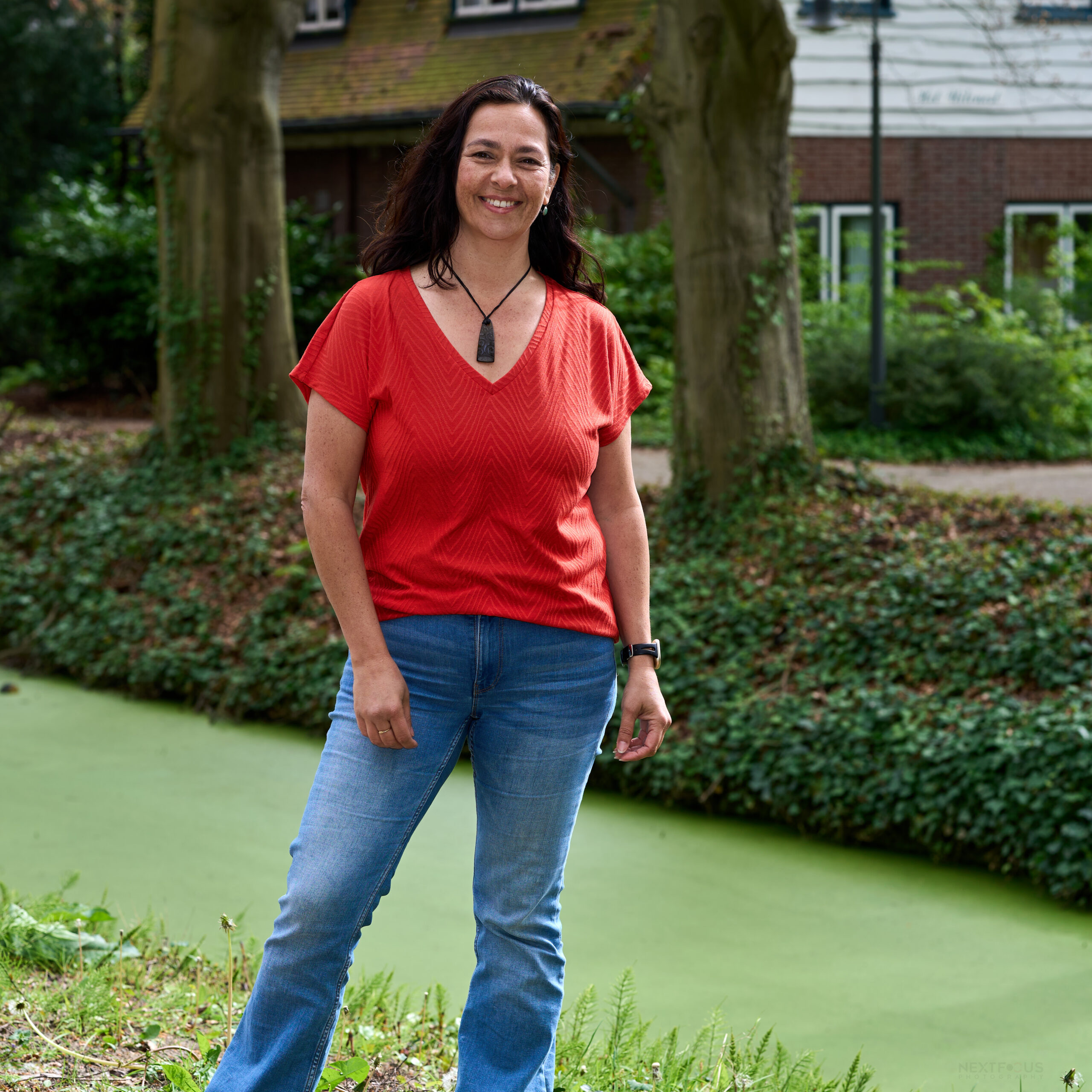 Naomi Bislip in oranje shirt vrolijk en volle lengte door Nextfocus